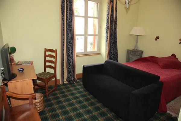 Chambre avec lit en bois et fauteuil