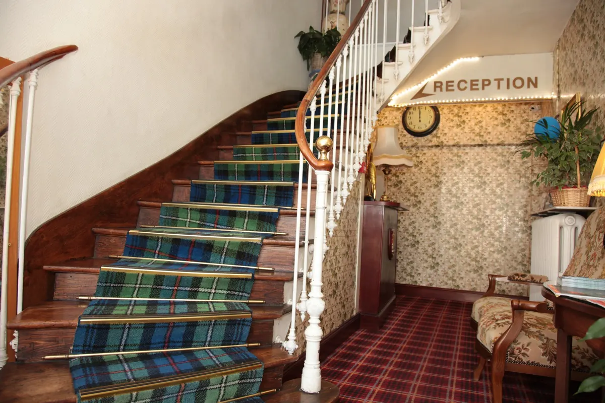 Escalier à moquette tartan et réception de l'hôtel